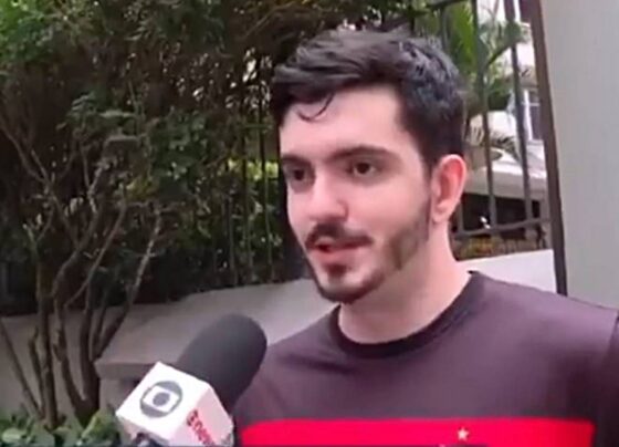 foto de homem jovem de pele branca com barba e cabelos escuros falando em microfone - metrópoles