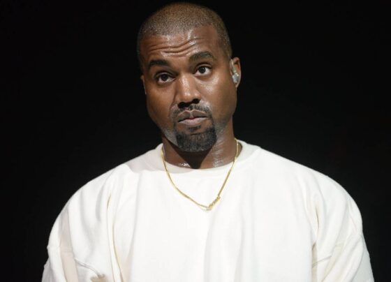 Homem preto vestindo camiseta branca. Ele também está usando um colar dourado rente ao pescoço