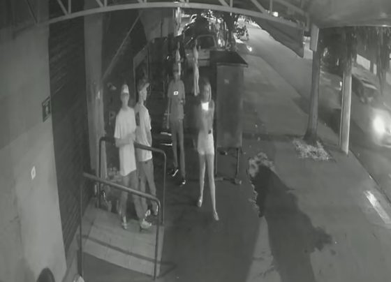 Mulher atirando com a arma do filho contra pessoas próximo a uma conveniência em Dourados (Foto: WhatsApp)